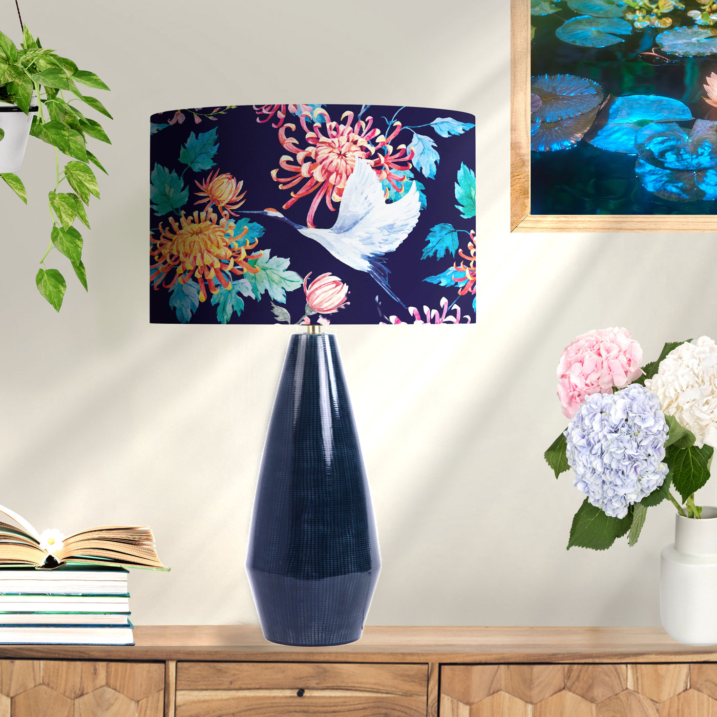 Japanese Cranes Cotton Lampshade in Blue with Copper Lining on blue lamp base next to books and flowers