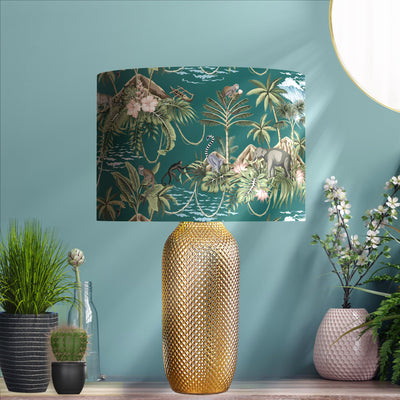 Green Lemur Island Cotton Lampshade with Mirror Copper Lining, pictured in living room setting on a gold lamp base