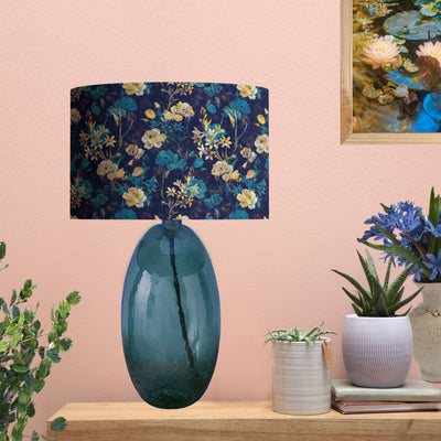 Navy Blue Gold Flower Lampshade with Mirror Copper Lining, pictured on blue glass lamp base in living room setting